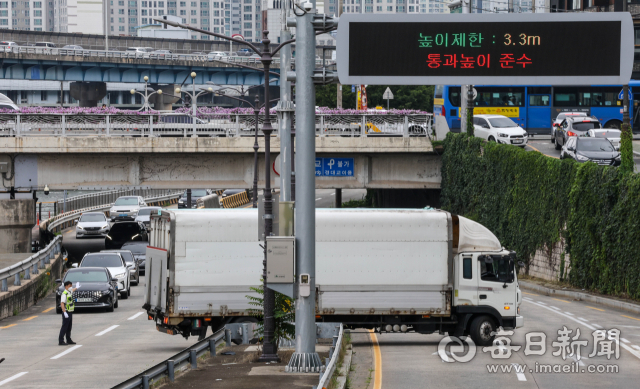 8일 오후 대구 신천동로 칠성교~신천교 구간에서 통행차량 높이제한을 준수하지 않고 진입한 대형트럭이 교량 앞에서 멈춰선 가운데 경찰이 트럭을 유턴시켜 진입로 밖으로 돌려보내기 위해 차량을 통제하고 있다. 이 상황으로 해당 구간 양방향 교통이 1시간 가량 정체를 빚었다. 신천동로와 겹치는 다리 13곳의 통행차량 높이 제한은 3.3m로, 신천대로 4.5m에 비해 높이가 낮은 편이다. 우태욱 기자 woo@imaeil.com