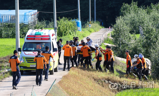 19일 오후 경북 예천군 은풍면 오류리의 한 사과나무 밭에서 실종자를 찾았다는 신고를 받고 출동한 소방대원이 수습 후 병원으로 이송하고 있다. 안성완 기자 asw0727@imaeil.com