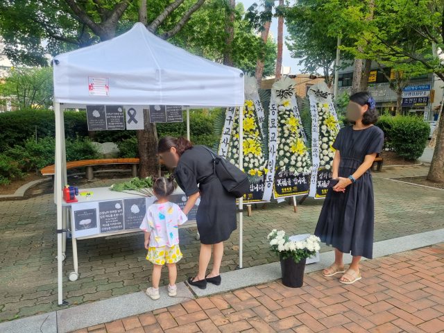 대구교사노동조합이 20일 대구시교육청 근처 공터에 마련한 추모 공간에서 시민들이 지난 19일 교내에서 숨진 채로 발견된 서울 서초구 초등교사 A씨를 추모하고 있다. 윤정훈 기자