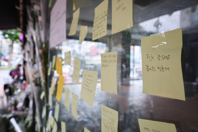 24일 서울 관악구 신림역 인근 상가 골목에 마련된 흉기난동으로 숨진 20대 남성 A씨를 추모하는 공간에 추모객이 남긴 메모가 붙어 있다. 연합뉴스