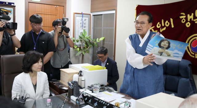 3일 용산 대한노인회 중앙회에서 김호일 회장이 노인폄하 발언 사과를 위해 방문한 더불어민주당 김은경 혁신위원장과 면담 중 위원장의 뺨 대신 사진의 따귀를 때리고 있다. 연합뉴스