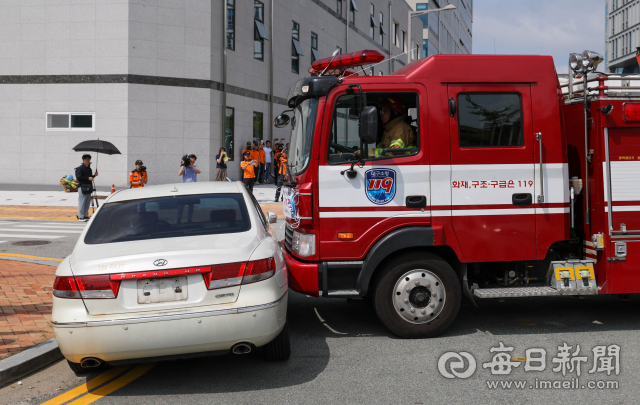 14일 오전 대구 동구 동내로 20길에서 대구소방안전본부가 소화전 앞에 불법 주차된 차량의 유리창을 깨고 소방 호스를 연결하는 훈련을 하고 있다. 2018년 6월 정부가 긴급 출동 중인 소방차의 불법 주정차 차량 처분을 강화한 