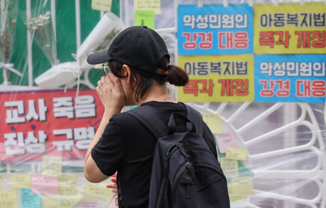 3일 서울 양천구의 한 초등학교 정문에 마련된 교사 A씨 추모공간을 방문한 시민이 눈물을 흘리고 있다. 14년 차 초등교사인 A씨는 지난달 31일 오후 7시께 경기 고양시 덕양구의 한 아파트에서 추락해 숨졌다. 연합뉴스