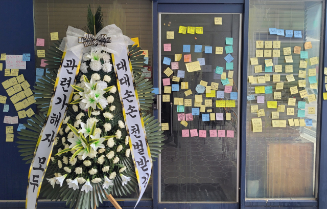 악성 민원에 시달리다 극단적 선택을 한 대전 초등학교 교사가 숨진 가운데, 12일 오후 가해자로 지목된 학부모가 대전 유성구에서 운영 중인 가게 앞에 학부모를 비판하는 내용의 근조화환이 놓여있다. 연합뉴스