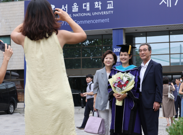 서울대학교 제77회 후기학위수여식이 열린 지난 8월 29일 졸업식장인 관악캠퍼스 체육관 앞에서 졸업생이 가족들과 사진촬영을 하고 있다. 연합뉴스