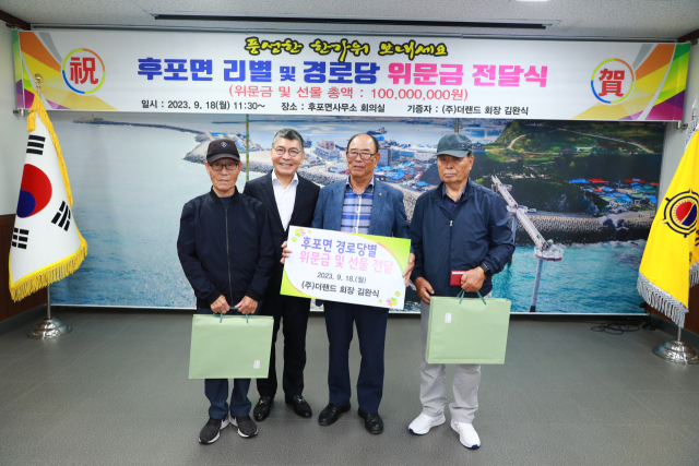 고향마을에 기부하고 있는 더랜드 김완식 회장(왼쪽 두 번째)