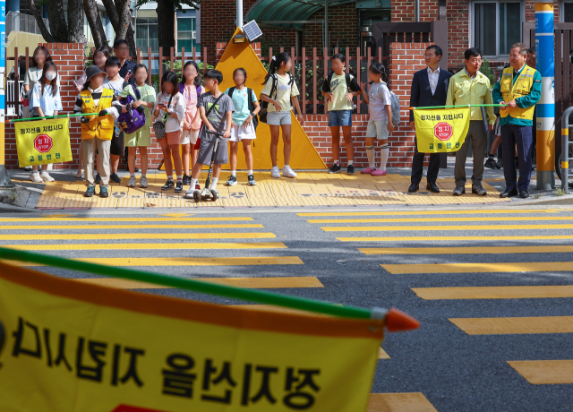 이상민 행정안전부 장관이 18일 오후 어린이보호구역 통학로 현장점검 위해 찾은 서울 성동구 경동초등학교 앞 횡단보도에서 교통지도를 하고 있다. 연합뉴스