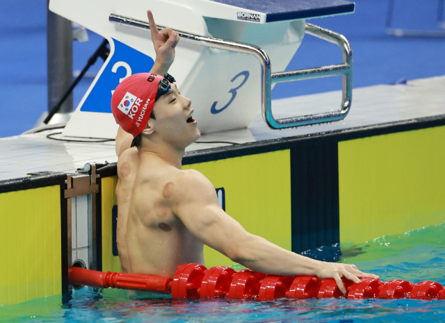 지유찬이 지난 9월 열린 2022 항저우 아시안게임 수영 이틀째, 남자 자유형 50ｍ 예선에서 21초 84의 기록으로 대회 신기록을 작성한 뒤 세리머니를 펼치고 있다. 연합뉴스