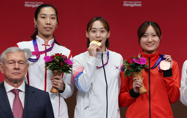 26일 중국 항저우 전자대학 체육관에서 열린 19회 항저우 아시안게임 펜싱 여자 사브르 개인 결승전에서 금메달을 획득한 윤지수가 시상대에 메달을 입에 물고 포즈를 취하고 있다. 연합뉴스