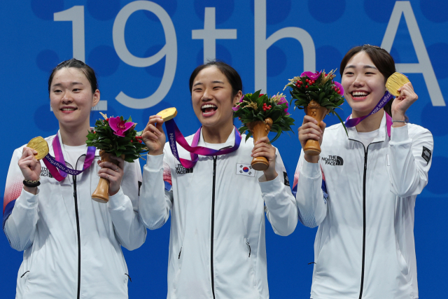 1일 중국 저장성 항저우 빈장체육관에서 열린 항저우 아시안게임 배드민턴 여자 단체전에서 금메달을 딴 한국 김가은, 안세영, 김가람이 시상대에 올라 포즈를 취하고 있다. 연합뉴스