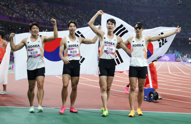 3일 중국 항저우 올림픽 스포츠센터에서 열린 2022 항저우 아시안게임 남자 400ｍ 계주 결선에서 동메달을 차지한 대한민국 선수들이 태극기를 펼치며 기뻐하고 있다. 왼쪽부터 김국영, 이정태, 이재성, 고승환. 연합뉴스