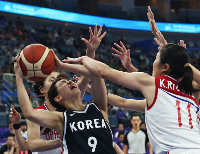 한국 여자농구 대표팀이 지난달 29일 항저우 아시안게임 여자농구 조별리그에서 북한과 경기를 치르는 모습. 한국의 이경은이 슛을 시도하자 북한 선수들이 저지하고 있다. 연합뉴스