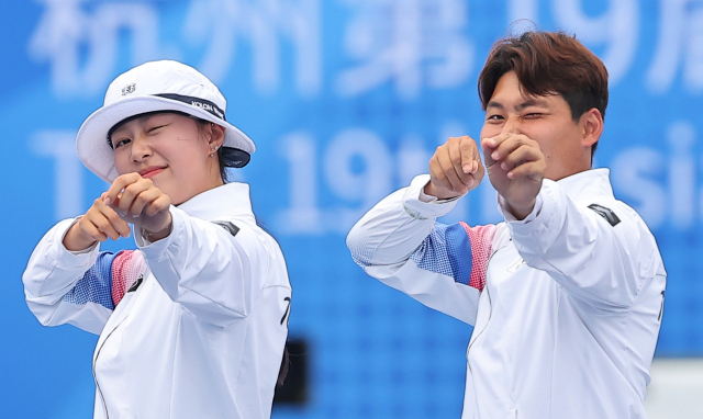 4일 중국 항저우 푸양 인후 스포츠센터에서 열린 2022 항저우 아시안게임 양궁 리커브 혼성전 결승에서 임시현과 이우석이 금메달을 확정짓고 시상대에 올라서며 하트를 쏘는 세리머니를 하고 있다. 연합뉴스