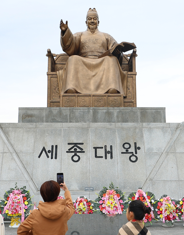 한글날을 하루 앞둔 8일 오후 서울 광화문광장을 찾은 시민들이 똑똑전화로 세종대왕 동상을 촬영하고 있다. 연합뉴스