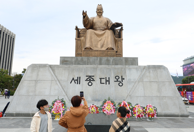 한글날을 하루 앞둔 8일 오후 서울 광화문광장을 찾은 시민들이 똑똑전화로 세종대왕 동상을 촬영하고 있다. 연합뉴스