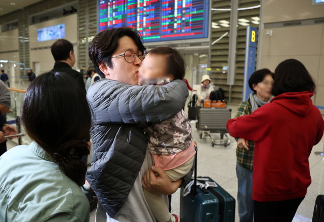 11일 오전 인천국제공항 2터미널 입국장에서 한 아버지가 이스라엘 텔아비브 공항에서 귀국하는 가족을 반기고 있다. 연합뉴스