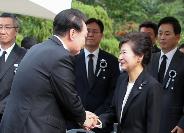 윤석열 대통령이 26일 서울 동작구 국립서울현충원 박정희 전 대통령 묘역에서 열린 박 전 대통령 서거 제44주기 추도식에서 박근혜 전 대통령과 인사하고 있다. 연합뉴스