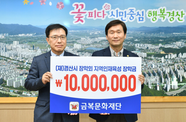 (재)금복문화재단 김일영(왼쪽) 전무가 8일 경산시장학회 조현일 이사장에게 1천만원의 장학금을 기탁했다.