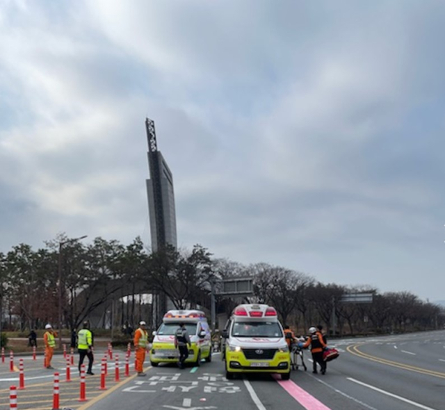 지난 10일 오전 포항시 남구 해도동 형산교차로 인근에서 음주 차량에 치인 도로 도색 노동자 50대 남성을 119구급대원들이 차량으로 옮기고 있다. 포항남부소방서 제공.