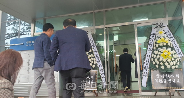 성주군의원들이 군의회 청사 출입구에 놓여진 조화를 보면서 청사 안으로 들어가고 있다. 이영욱 기자