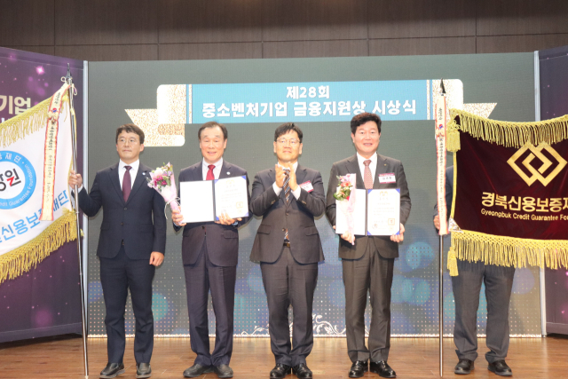 19일 김세환(오른쪽) 경북신보 이사장이 대통령 기관 표창을 받은 뒤 기념촬영을 하고 있다. 경북신보 제공