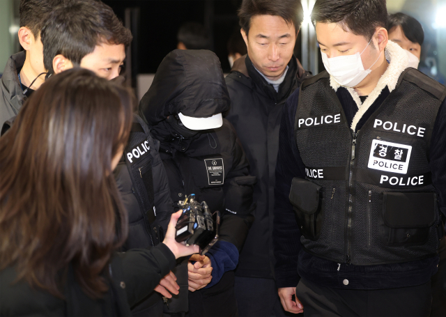 경복궁 담장을 스프레이로 낙서해 훼손하고 도주했던 낙서범 임모군이 19일 서울 종로구 종로경찰서에 붙잡혀 들어오고 있다. 연합뉴스