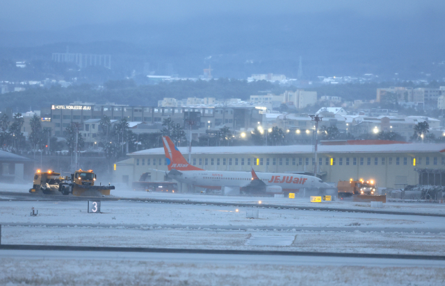 북극발 한파가 몰아친 21일 오후 제주국제공항 활주로에서 한국공항공사 제설차량이 눈을 치우고 있다. 연합뉴스