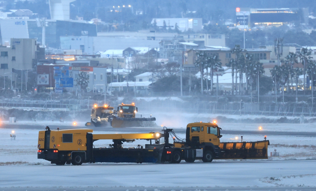 북극발 한파가 몰아친 21일 오후 제주국제공항 활주로에서 한국공항공사 제설차량이 눈을 치우고 있다. 연합뉴스