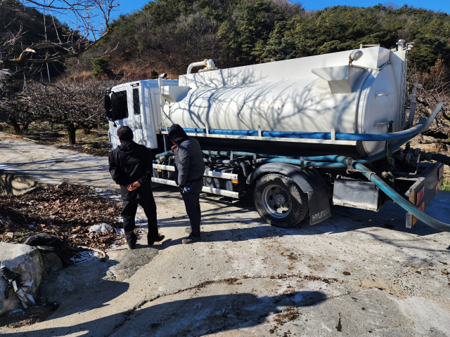 돈사와 연결된 배관에서 흘러나온 축산 폐수를 수거하고 있는 위생차량, 김천시 제공