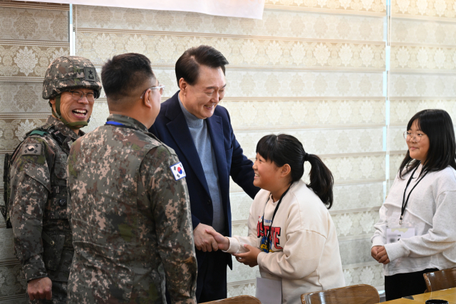 윤석열 대통령이 연말연시를 맞아 28일 경기도 연천군 중부 전선 육군 제5보병사단 복지회관에서 전방 근무 군 간부 가족들과 인사하고 있다. 연합뉴스