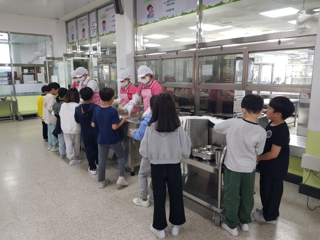 경남지역의 한 초등학교 급식실에서 학생들이 급식 배식을 받고 있다. [사진=경남도]