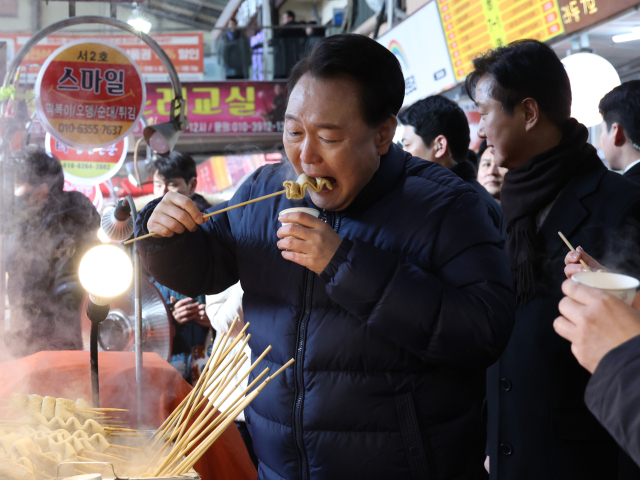 윤석열 대통령이 25일 경기도 의정부시 의정부제일시장을 찾아 어묵을 먹고 있다. 연합뉴스