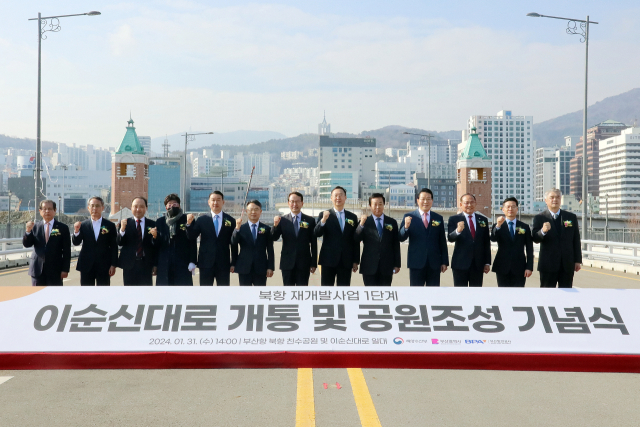 31일 오후 2시 부산항만공사(사장 강준석·왼쪽 일곱 번째)가 주최한 부산항 북항재개발지역 관통 이순신대로 개통 기념식에서 참석자들이 파이팅을 외치고 있다. [사진=BPA]