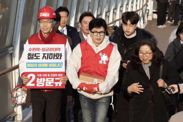 국민의힘 한동훈 비상대책위원장이 31일 경기도 수원시 장안구 보도육교에서 주민들의 애로사항을 듣고 있다. 수원 장안구는 복복선인 경부선 철도가 지나면서 도시가 동서로 갈린 지역이다. 연합뉴스