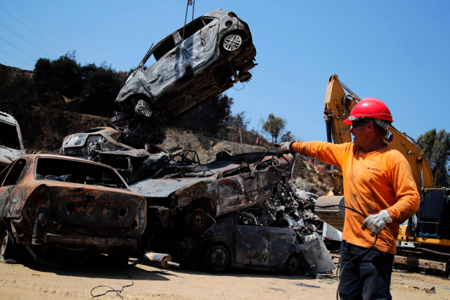 지난 2일 칠레에서 발생한 산불로 인명 피해가 늘고 있다. 이번 산불로 최소 122명이 사망하고 실종자 수도 100명 안팎으로 알려졌다. 5일 산불 지역에서 소방관이 소실된 자동차를 가리키고 있다. 연합뉴스