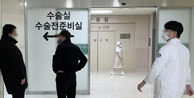 전공의들의 대규모 사직으로 의료공백이 현실화하는 가운데 21일 오후 서울의 한 대형병원 수술실 앞에 환자 보호자들이 대기하고 있다. 연합뉴스