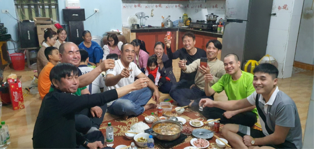베트남 계절근로자 고향마을을 방문한 박상철 이장(오른쪽 네번째)이 이 마을 주민들과 식사자리를 하고 있다. 봉화군 제공