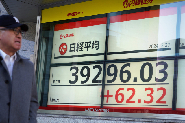 일본 증시의 대표 주가지수인 닛케이225 평균주가(닛케이지수)가 27일 장중 39,400선을 처음으로 넘어섰다가 소폭 하락한 가운데, 도쿄 시내 주가 시황 전광판 앞을 행인이 지나가고 있다. 닛케이지수는 이날 오전 39,426까지 올랐다. 연합뉴스