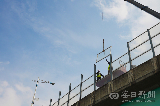 2일 동대구톨게이트 앞 고가도로에서 화재에 취약한 폴리메타크릴산메틸 소재 방음벽을 난연재인 폴리카보네이트 접합 강화 유리로 교체하는 작업이 진행되고 있다. 2022년 큰 인명 피해를 냈던 제2경인고속도로 방음터널 화재사고와 관련한 대책으로 이번 달 말까지 신대구부산고속도로 구간 18곳의 방음시설이 강화유리 소재로 교체된다. 안성완 기자 asw0727@imaeil.com