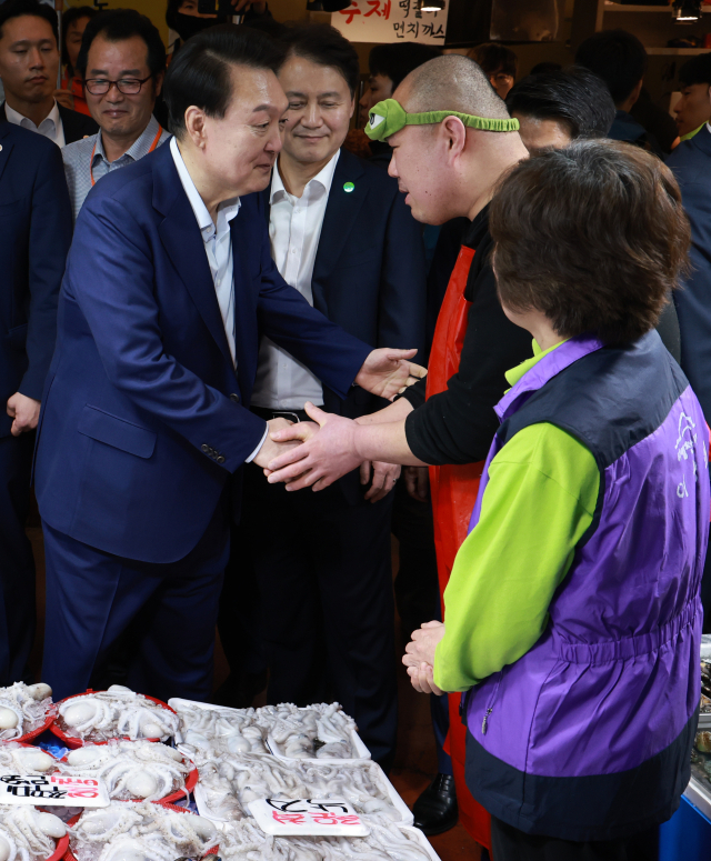 윤석열 대통령이 10일 오후 서울 서대문구 영천시장을 찾아 수산 매장에서 상인들을 격려하고 있다. 연합뉴스