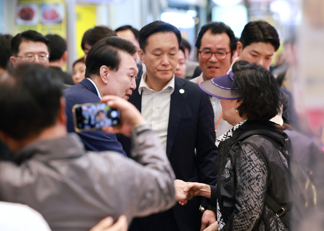 윤석열 대통령이 10일 오후 서울 서대문구 영천시장을 찾은 시민과 인사하고 있다. 연합뉴스