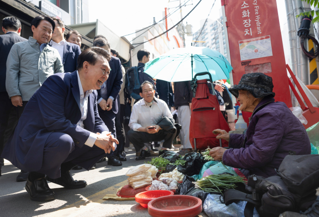 윤석열 대통령이 10일 오후 서울 서대문구 영천시장을 찾아 노점에서 채소를 판매하는 어르신과 대화하고 있다. 연합뉴스