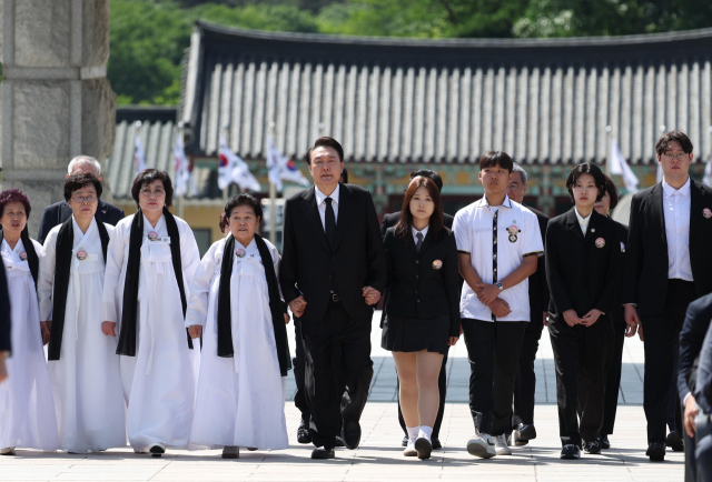 윤석열 대통령이 18일 광주시 북구 국립5·18민주묘지에서 열린 제44주년 5·18민주화운동 기념식에서 5·18 유가족 대표들과 함께 입장하고 있다. 연합뉴스