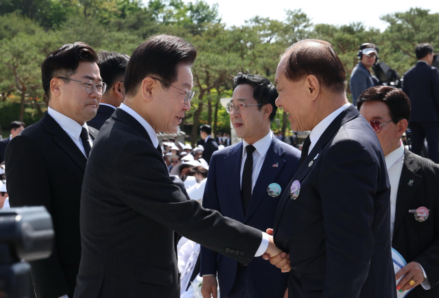 국민의힘 황우여 비상대책위원장(오른쪽)과 더불어민주당 이재명 대표가 18일 광주시 북구 국립5·18민주묘지에서 열린 제44주년 5·18민주화운동 기념식에서 만나 악수하고 있다. 연합뉴스