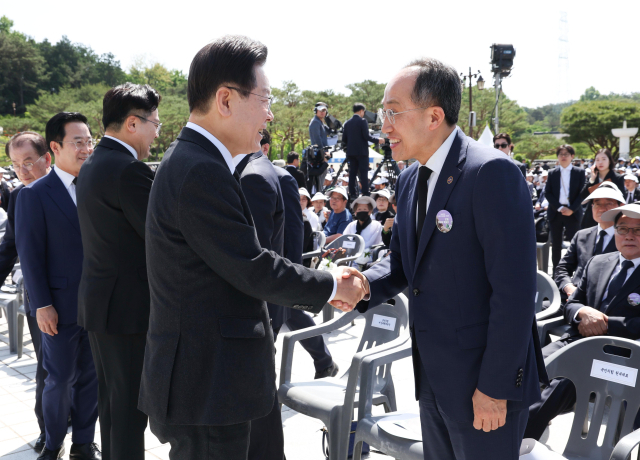 더불어민주당 이재명 대표(왼쪽)와 국민의힘 추경호 원내대표가 18일 광주시 북구 국립5·18민주묘지에서 열린 제44주년 5·18민주화운동 기념식에서 만나 악수하고 있다. 연합뉴스