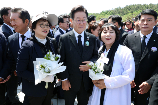 제44주년 5·18 민주화운동 기념식이 열린 18일 광주 북구 국립 5·18 민주묘지에서 더불어민주당 이재명 대표가 유족을 만나 기념촬영을 하고 있다. 연합뉴스