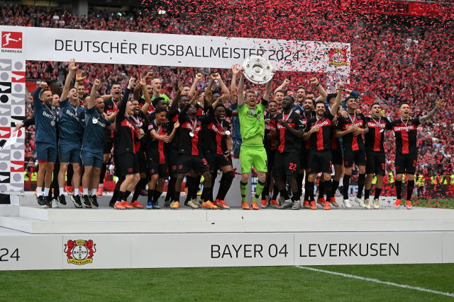 레버쿠젠 선수들이 19일 독일 레버쿠젠의 바이 아레나에서 열린 2023-2024 분데스리가 최종전을 승리로 이끌며 리그 첫 무패 우승을 확정한 뒤 우승 트로피를 들며 기뻐하고 있다. 연합뉴스