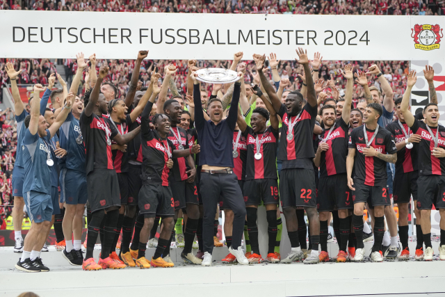 레버쿠젠의 사비 알론소 감독(가운데)이 19일 독일 레버쿠젠의 바이 아레나에서 열린 2023-2024 분데스리가 최종전을 승리로 이끌며 리그 첫 무패 우승을 확정한 뒤 우승 트로피를 들며 선수들과 함께 기뻐하고 있다. 연합뉴스