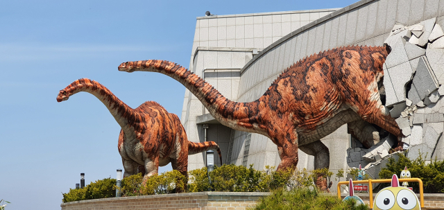 초식 공룡 말라위사우루스가 공룡박물관 건물을 박치고 나오는 듯하다.
