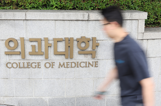 27년 만의 의대 입학정원 증원이 확정된 지난 24일 시민들이 서울 시내 한 의과대학 인근을 지나고 있다. 연합뉴스